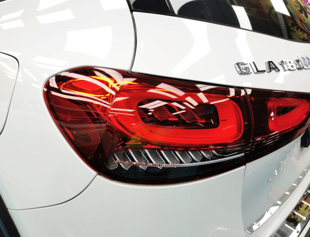 The coated bonnet of the Mercedes-Benz GLA180 under workshop lighting.