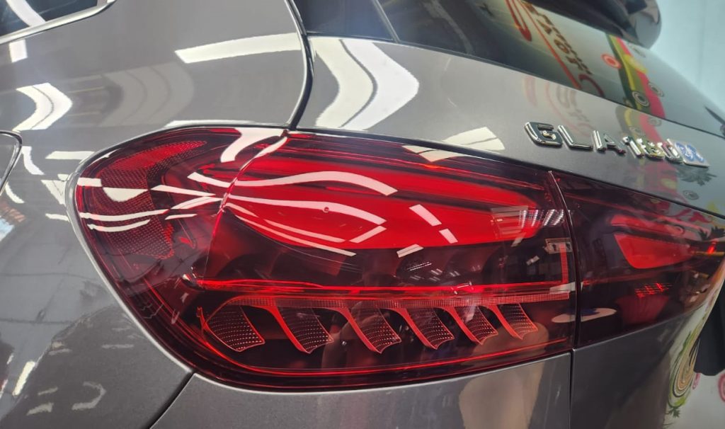 The coated bonnet of the Mercedes-Benz GLA180 under workshop lighting.
