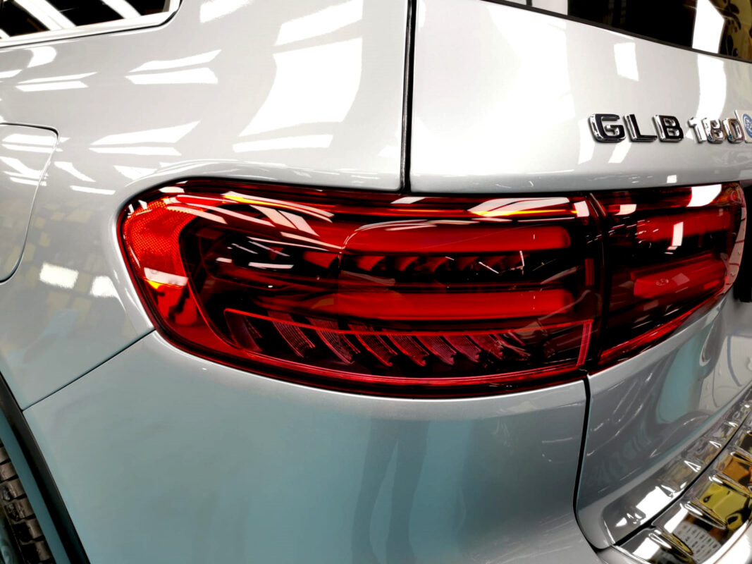 The coated bonnet of the Mercedes-Benz GLB 180 under workshop lighting.
