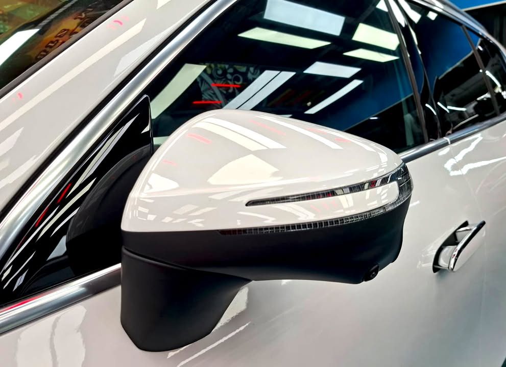 White wing mirror on the GLB 200 with ceiling lights reflected in the paint.