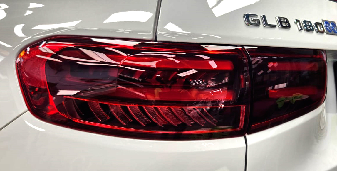 The coated bonnet of the Mercedes-Benz GLB180 under workshop lighting.