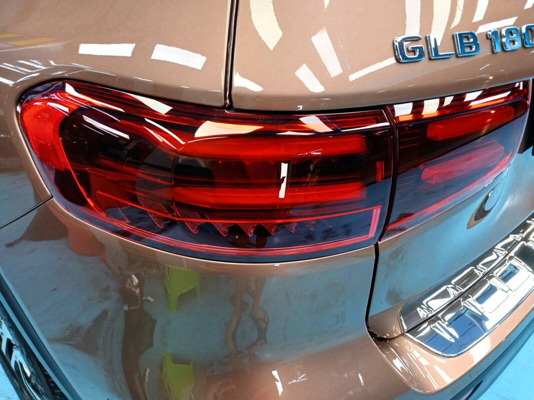 The coated bonnet of the Mercedes-Benz GLB180 under workshop lighting.