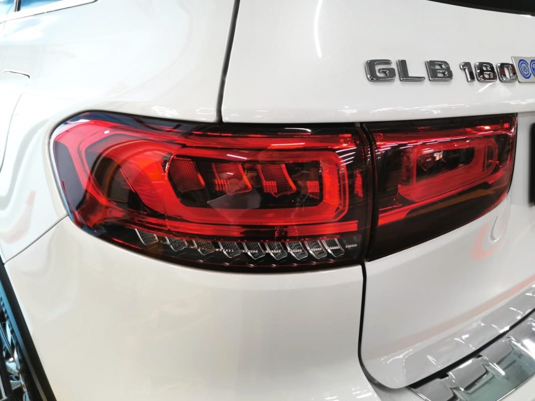 The coated bonnet of the Mercedes-Benz GLB180 under workshop lighting.
