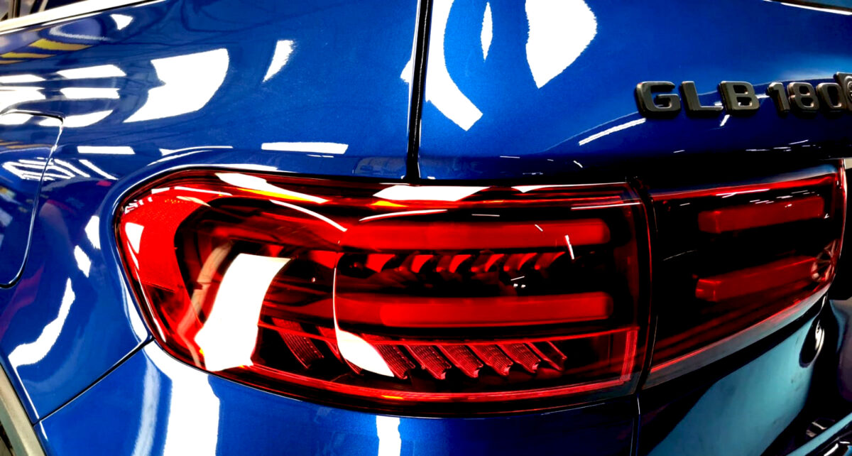 The coated bonnet of the Mercedes-Benz GLB180 under workshop lighting.