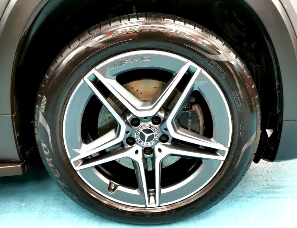 The coated bonnet of the Mercedes-Benz GLB200 under workshop lighting.