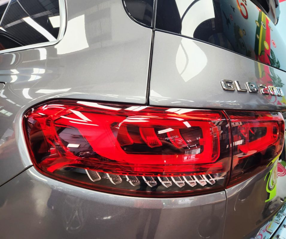 The coated bonnet of the Mercedes-Benz GLB200 under workshop lighting.