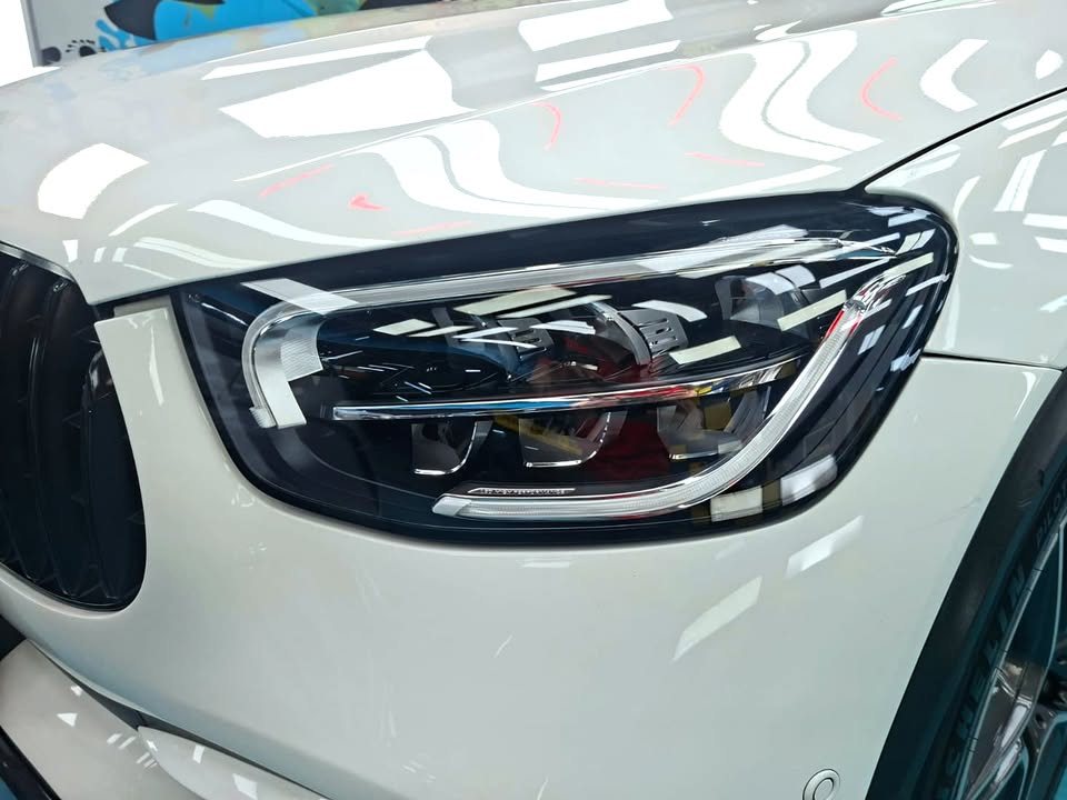 Close-up of the headlight with reflections in the white wing.