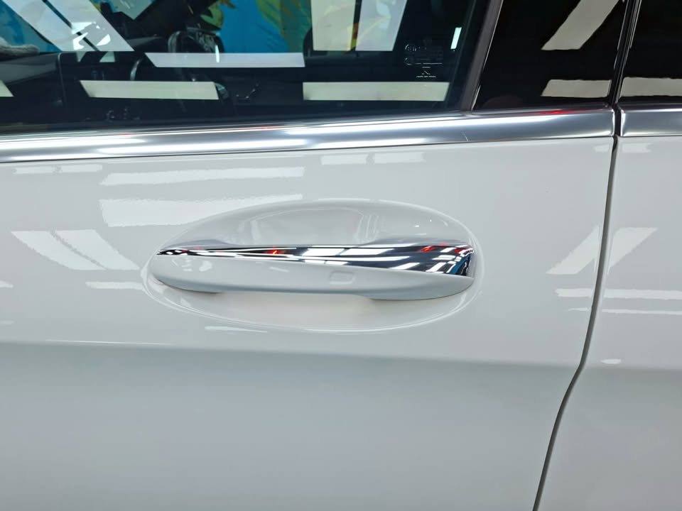 Chrome door handle on the white door panel.