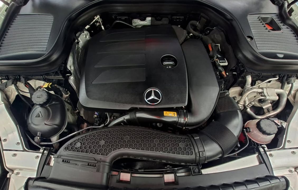 Engine bay with engine cover and Mercedes-Benz star.