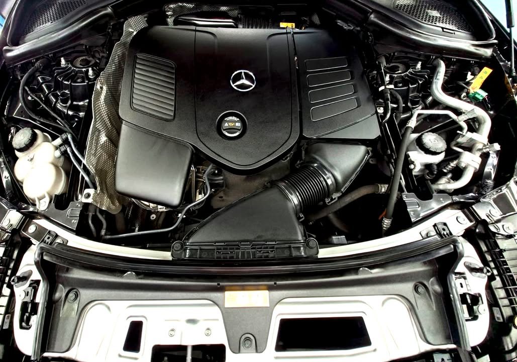 Engine bay with the engine cover and Mercedes-Benz star.