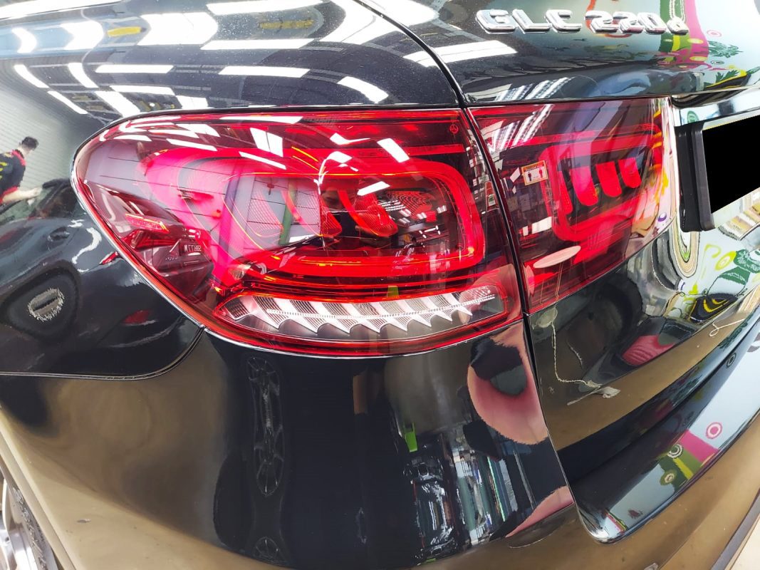 The coated bonnet of the Mercedes-Benz GLC220d under workshop lighting.