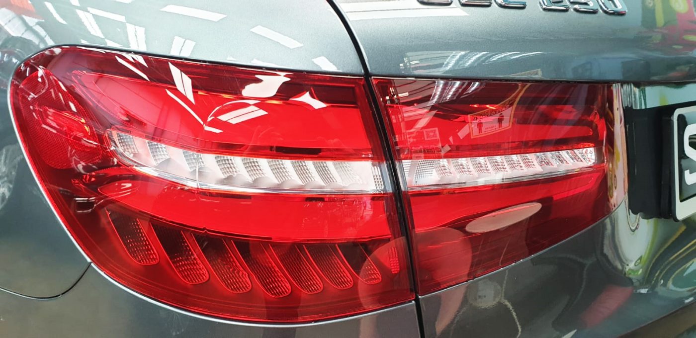 The coated bonnet of the Mercedes-Benz GLC250 AMG under workshop lighting.