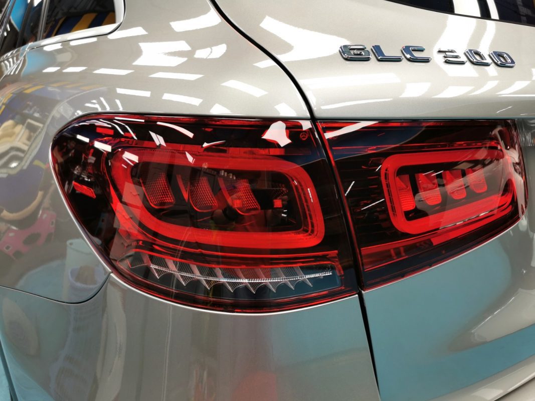 The coated bonnet of the Mercedes-Benz GLC300 AMG under workshop lighting.