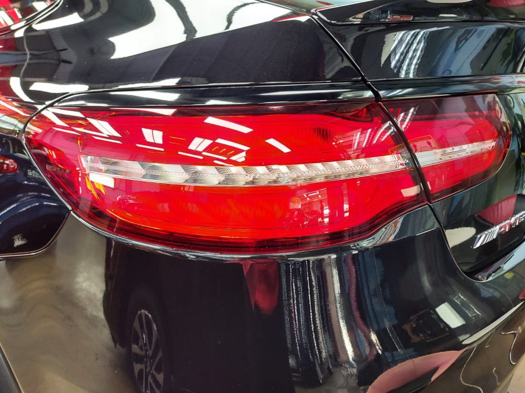 The coated bonnet of the Mercedes-Benz GLE450 AMG under workshop lighting.