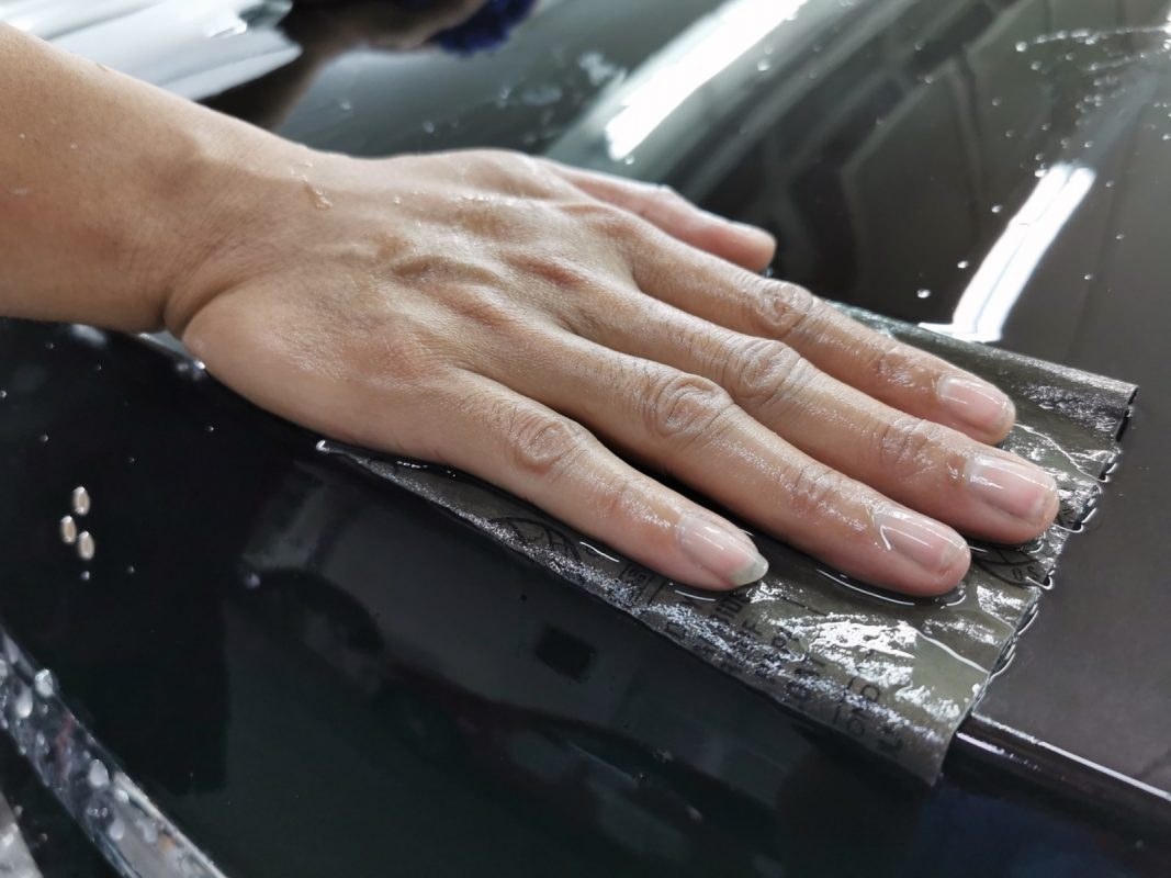 Wet-sanding the S320L's panels to smooth the existing paintwork.