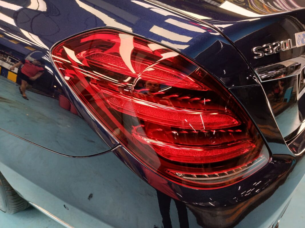 The coated bonnet of the Mercedes-Benz S320L under workshop lighting.