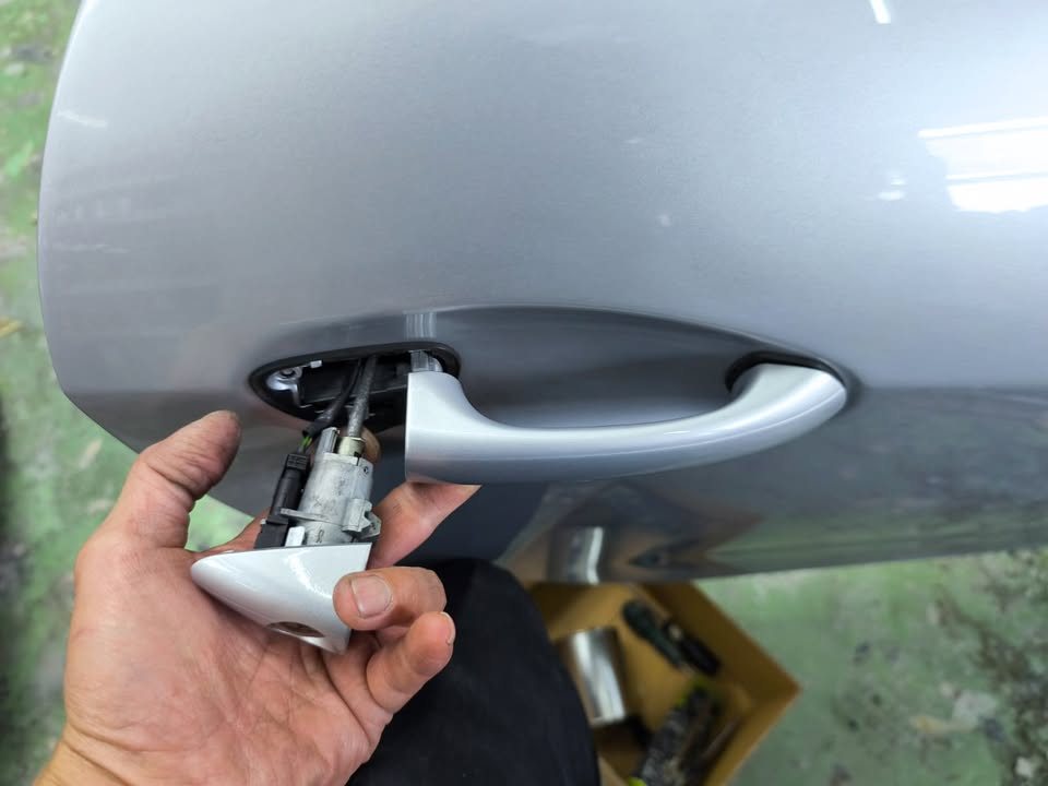 Door handle being removed from the silver door panel.