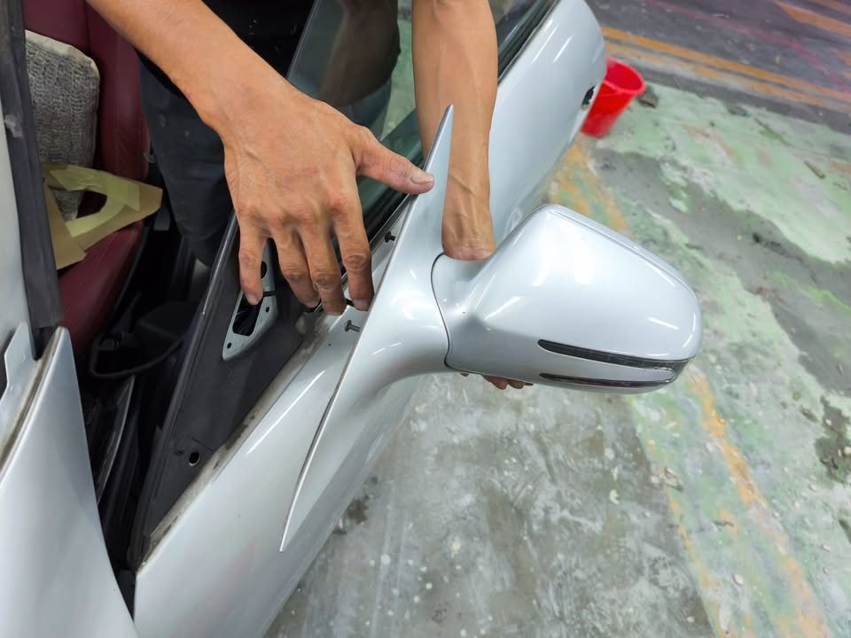 Side mirror being removed from the driver's door.
