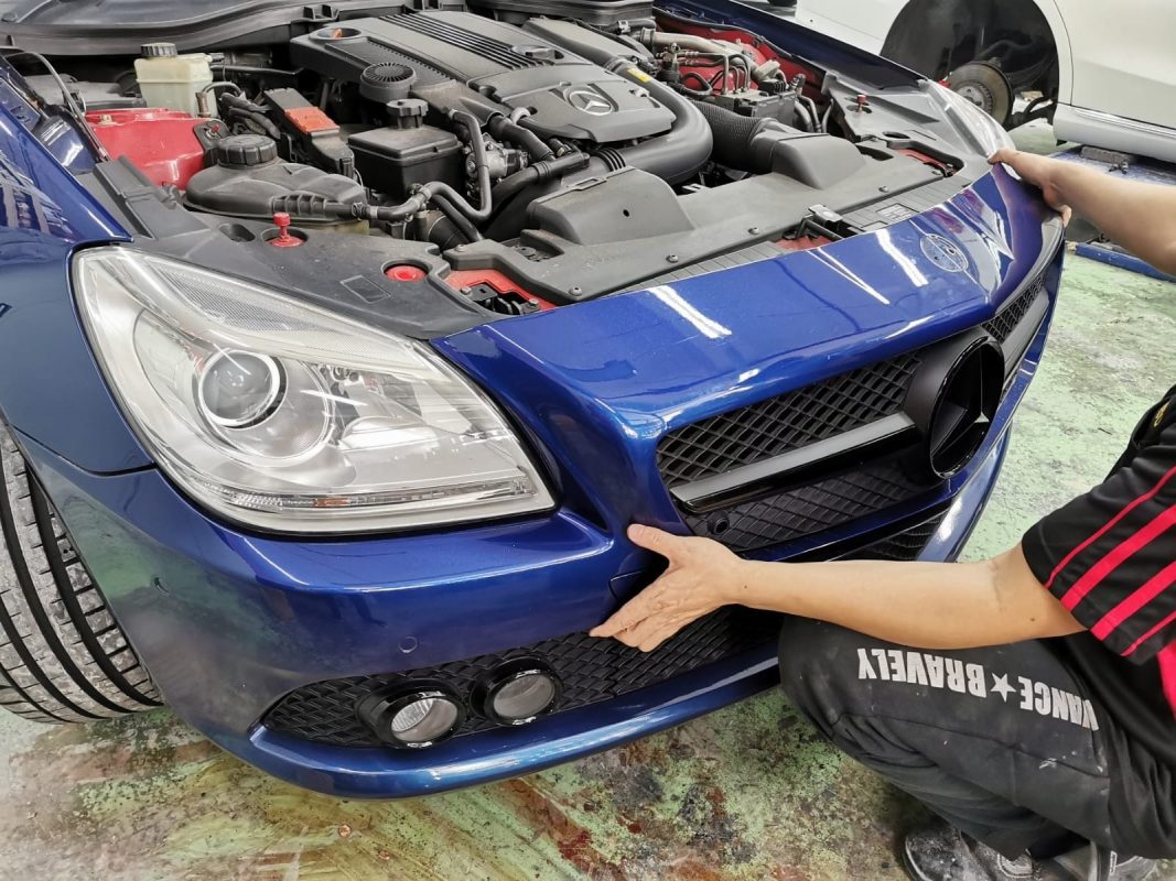 The Mercedes-Benz SLK200 at an early stage of the job, with parts being dismantled.