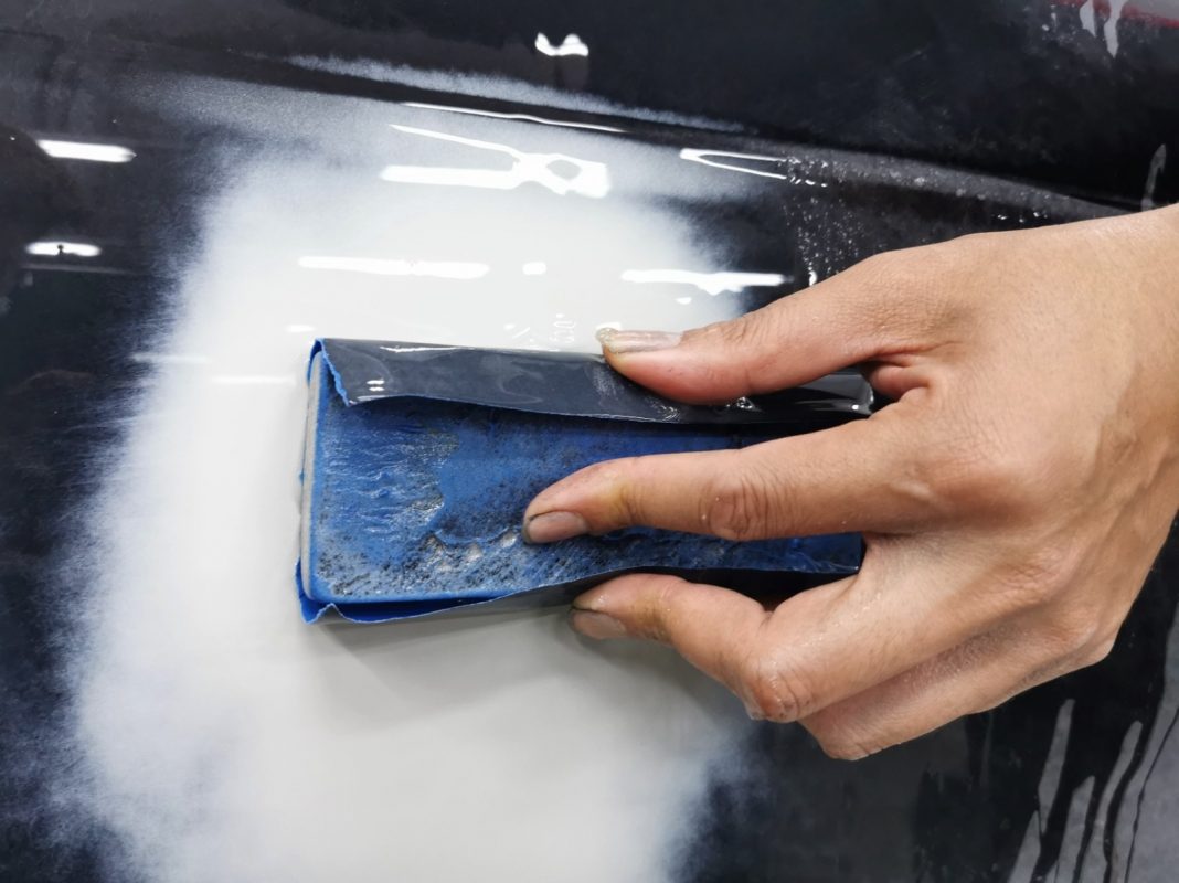 Wet-sanding the SLK200's panels to smooth the existing paintwork.