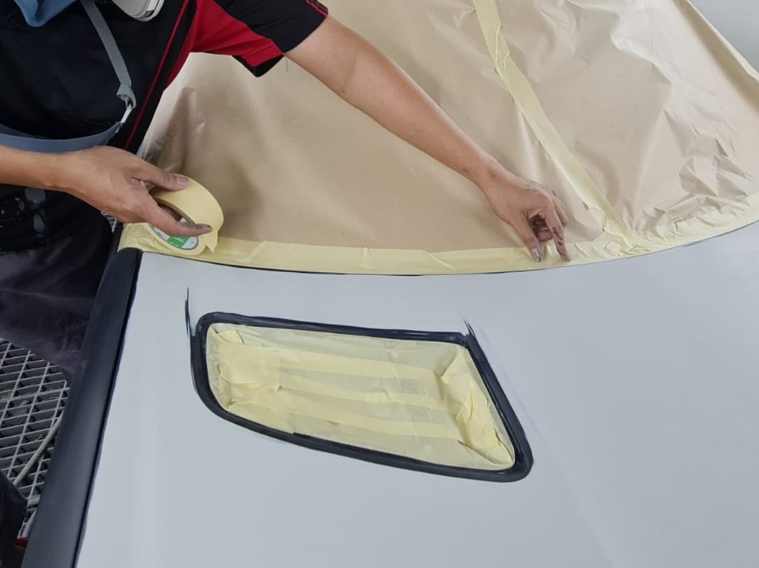 Non-painted surfaces being masked off on the SLK200 before spraying.