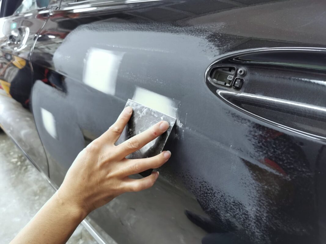 Body filler levelling a panel on the Mercedes-Benz C200 before paint.