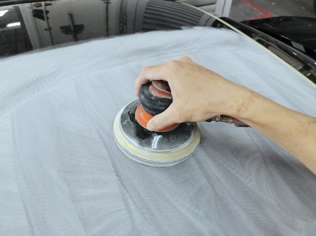 Machine-sanding the C200's roof to take the surface back.