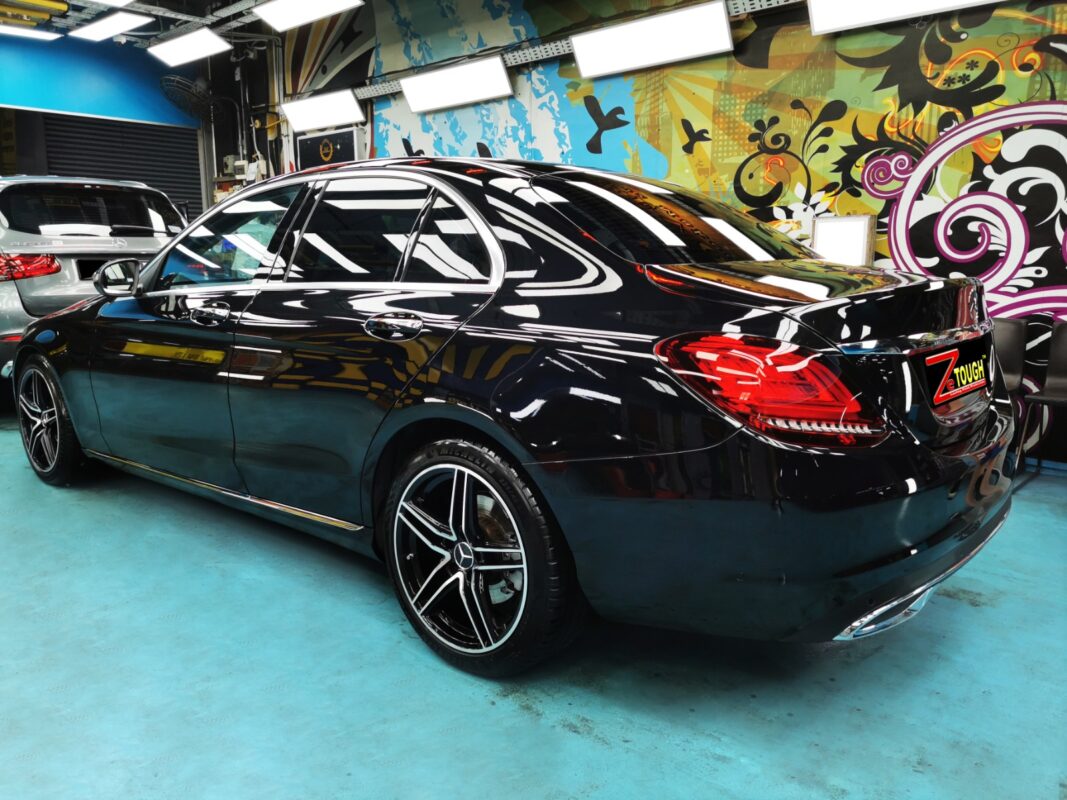 A Revol Carz painter laying the new coat onto the Mercedes-Benz C200 in the spray booth.