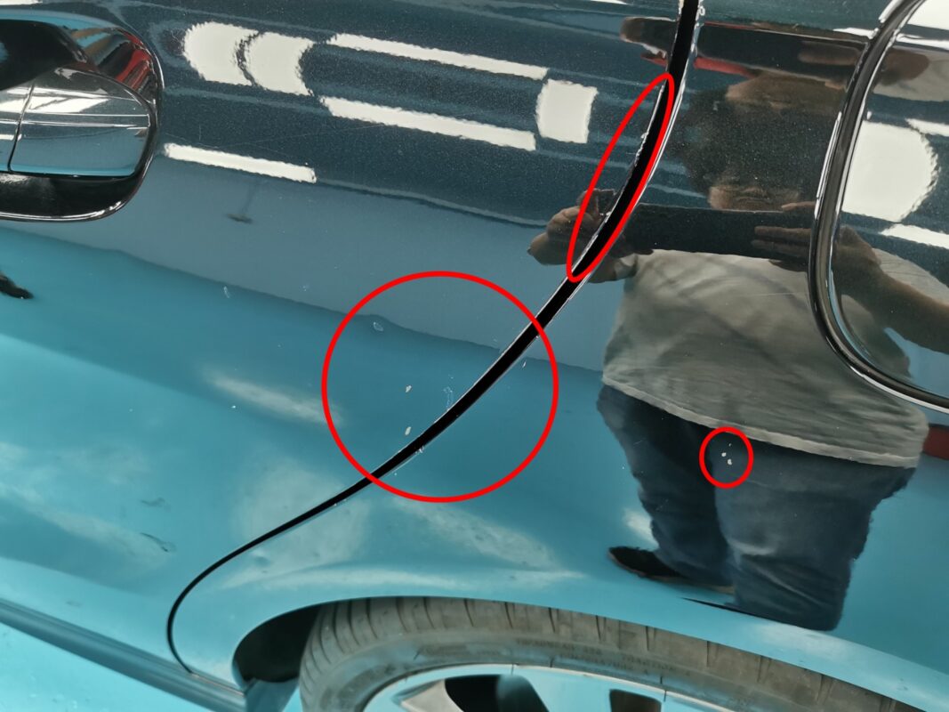 Stone chips and scratches circled on a panel of the Mercedes-Benz CLA180 during inspection.