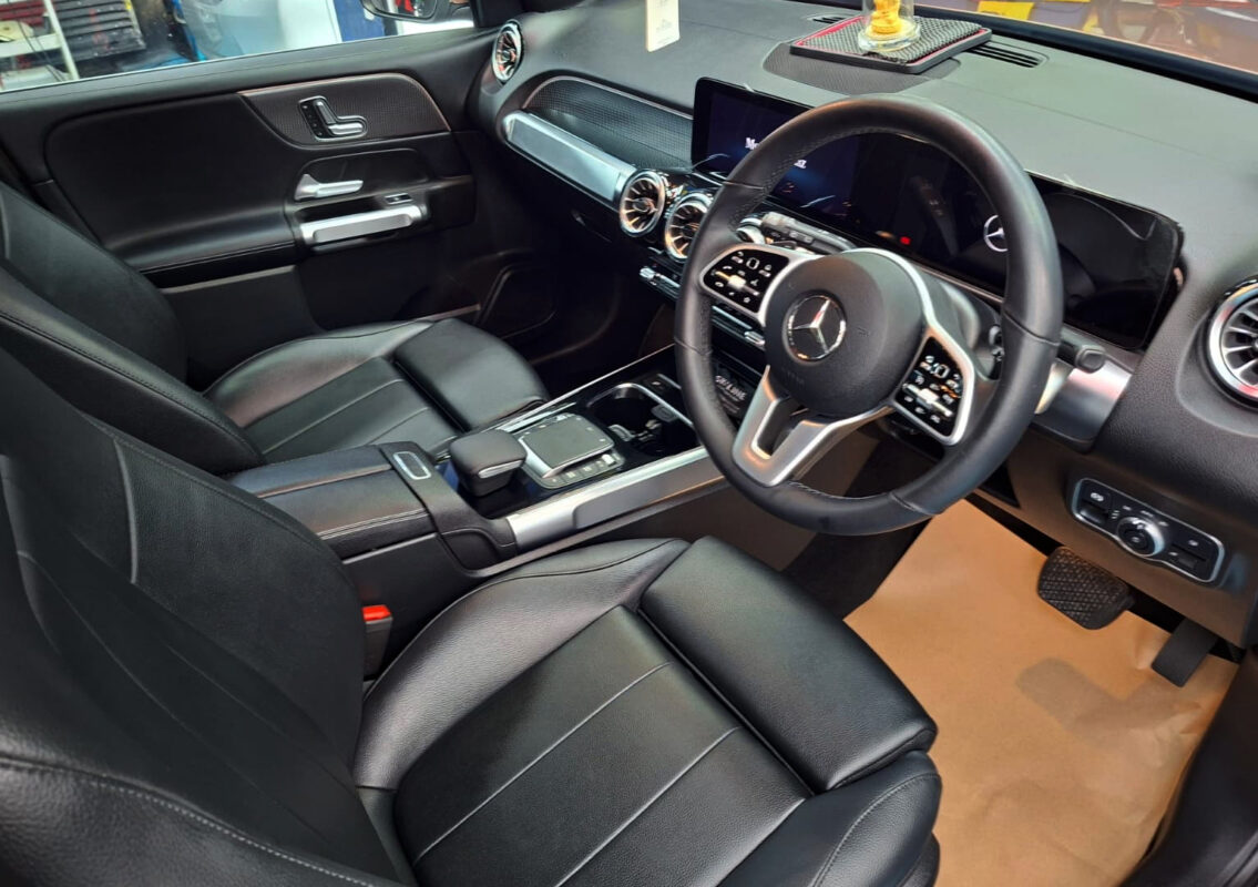 Reflections across the coated panels of the Mercedes-Benz GLB180.