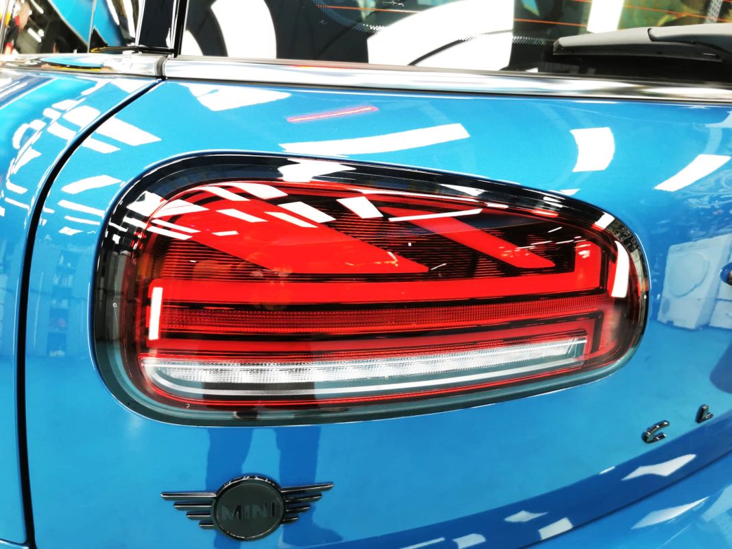 The coated bonnet of the MINI Clubman Cooper under workshop lighting.