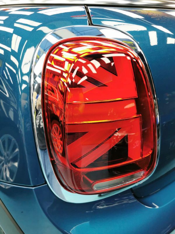 The coated bonnet of the MINI under workshop lighting.