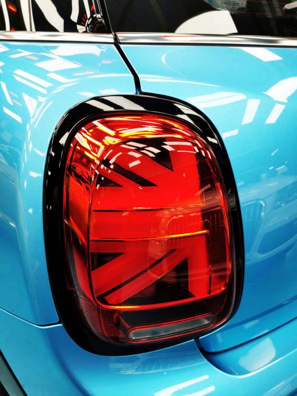 The coated bonnet of the MINI Cooper under workshop lighting.