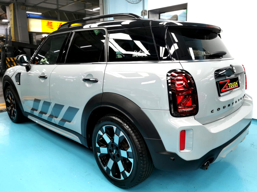 The coated bonnet of the MINI Countryman under workshop lighting.