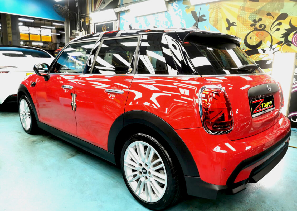 The coated bonnet of the MINI One under workshop lighting.