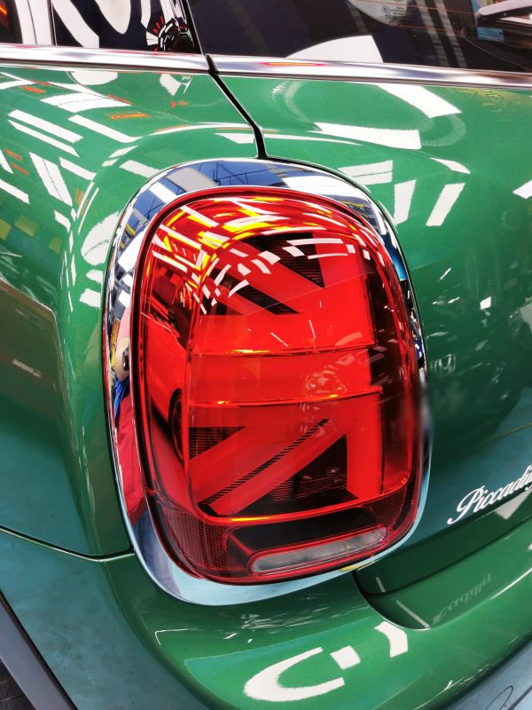 The coated bonnet of the MINI One under workshop lighting.