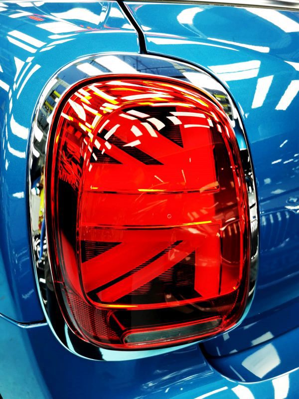 The coated bonnet of the MINI One under workshop lighting.