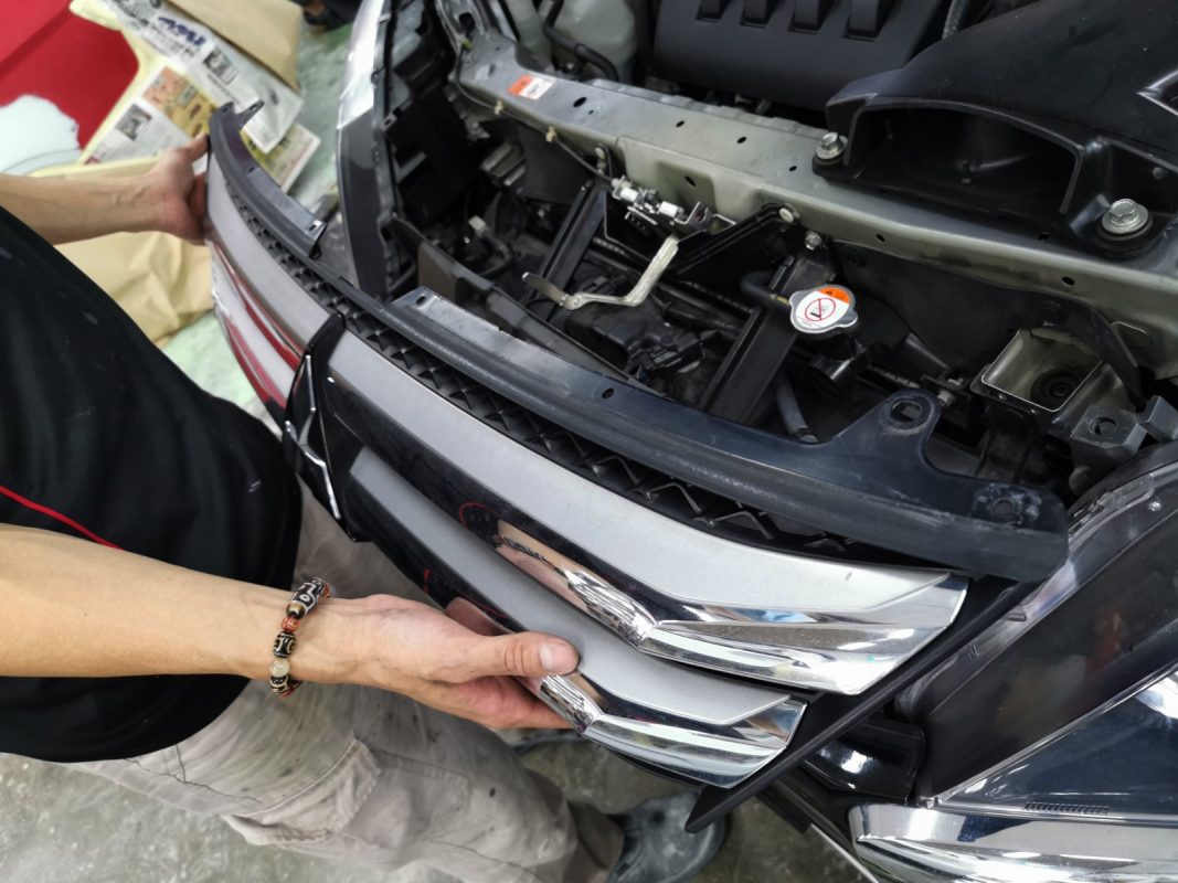 Technician dismantling trim and panels from the Mitsubishi Eclipse Cross during strip-down.