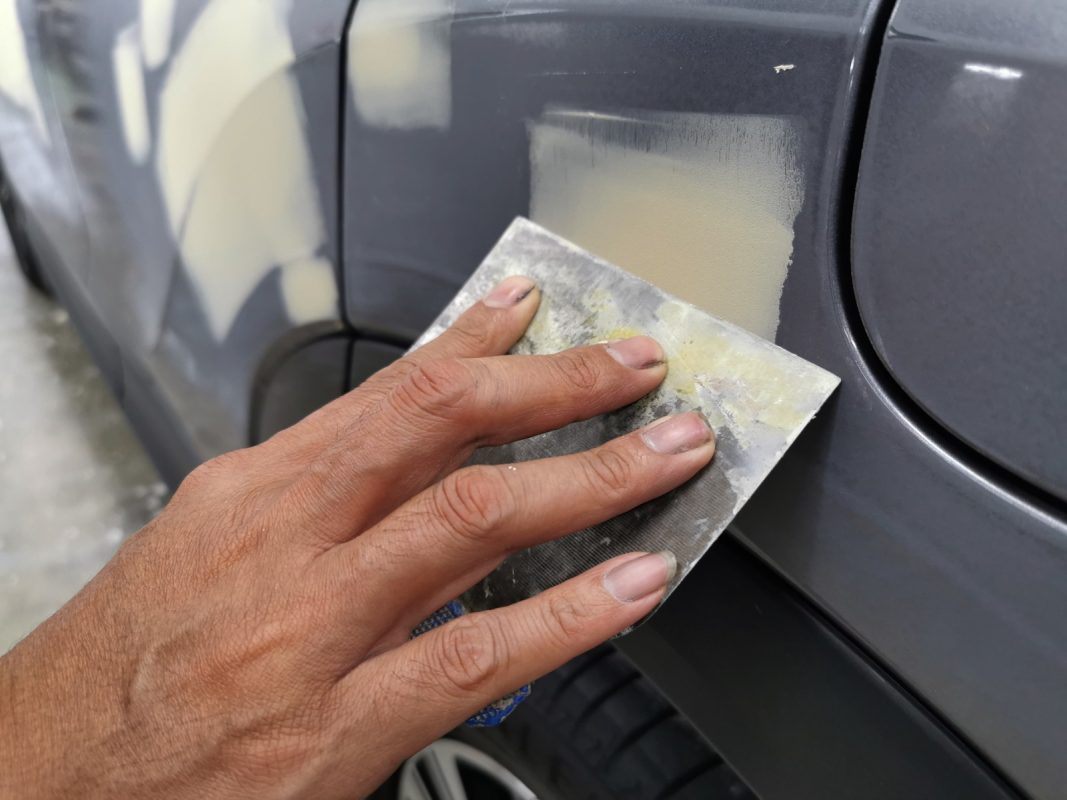 Putty applied to damaged areas on the Eclipse Cross body panels.