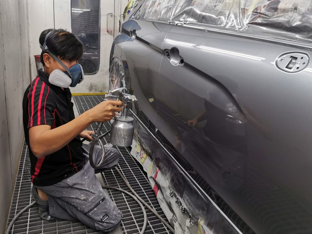 The Mitsubishi Eclipse Cross in the spray booth, new coat being applied.