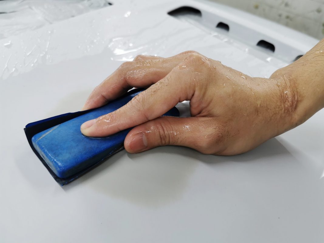 Wet-sanding the Evo's panels to smooth the surface.