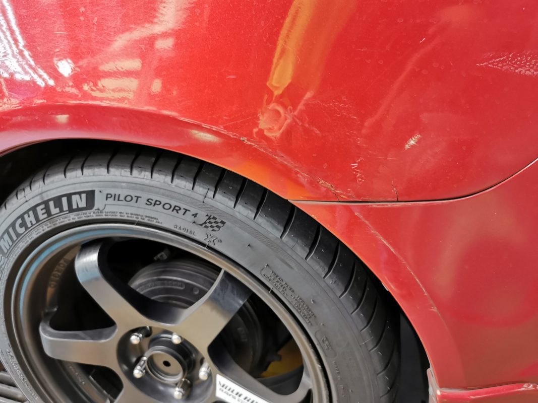 Aged paintwork on the Mitsubishi Lancer at intake.
