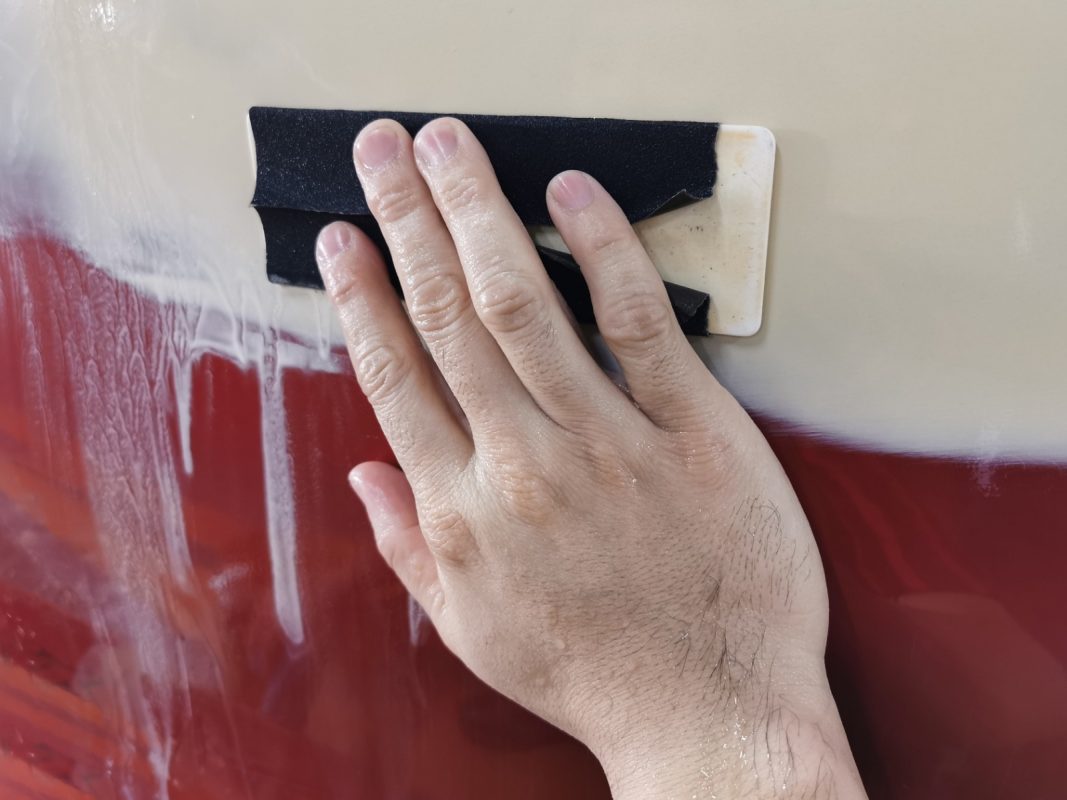 Wet-sanding the Lancer's panels to smooth the existing paintwork.