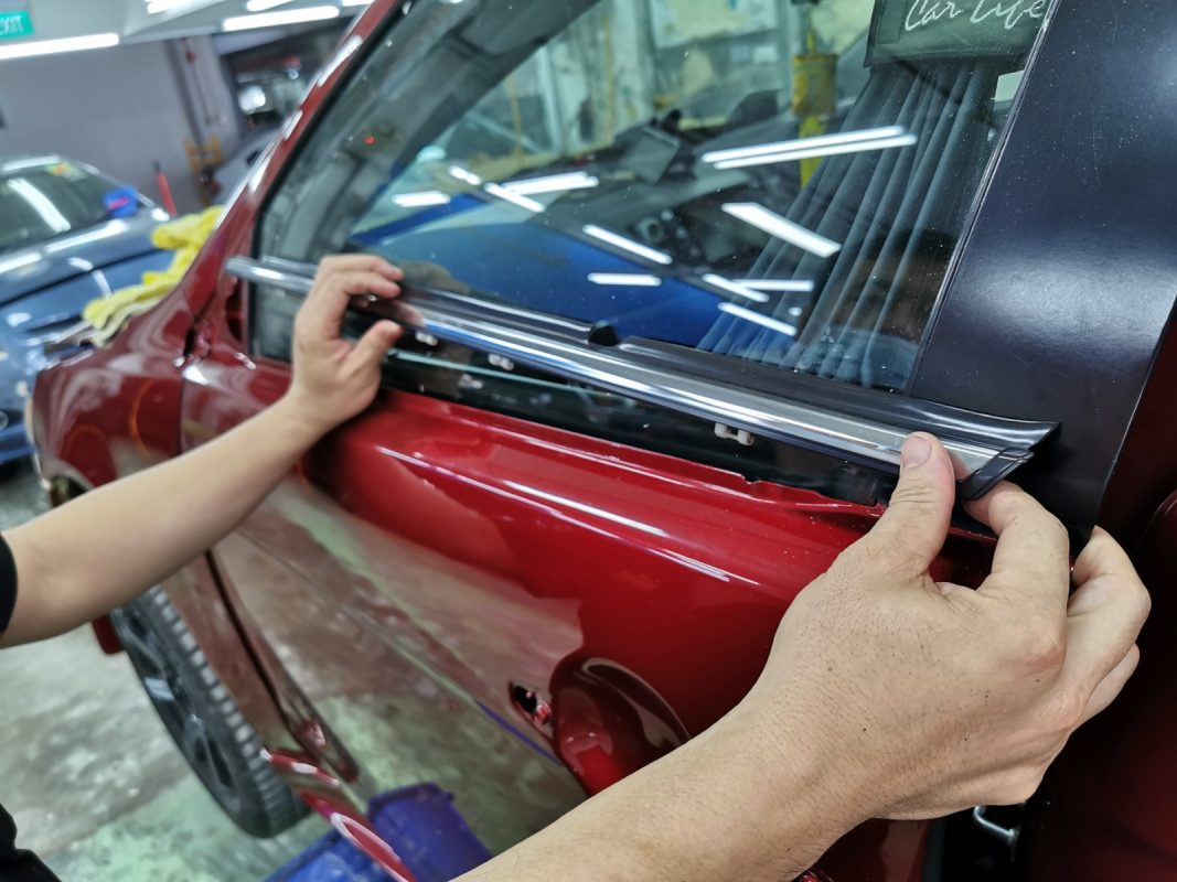 Previously removed car parts being refitted onto the Lancer.
