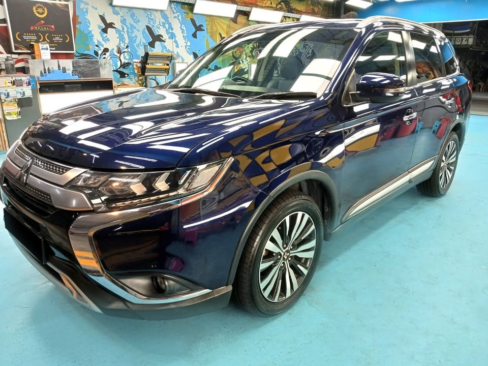 Dark blue Mitsubishi Outlander from the front three-quarter before the respray.