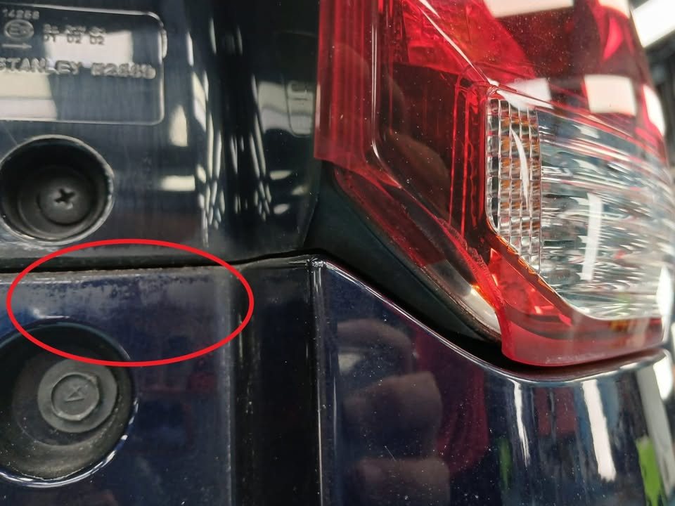 Paint damage beside the Outlander's tail lamp circled in red.