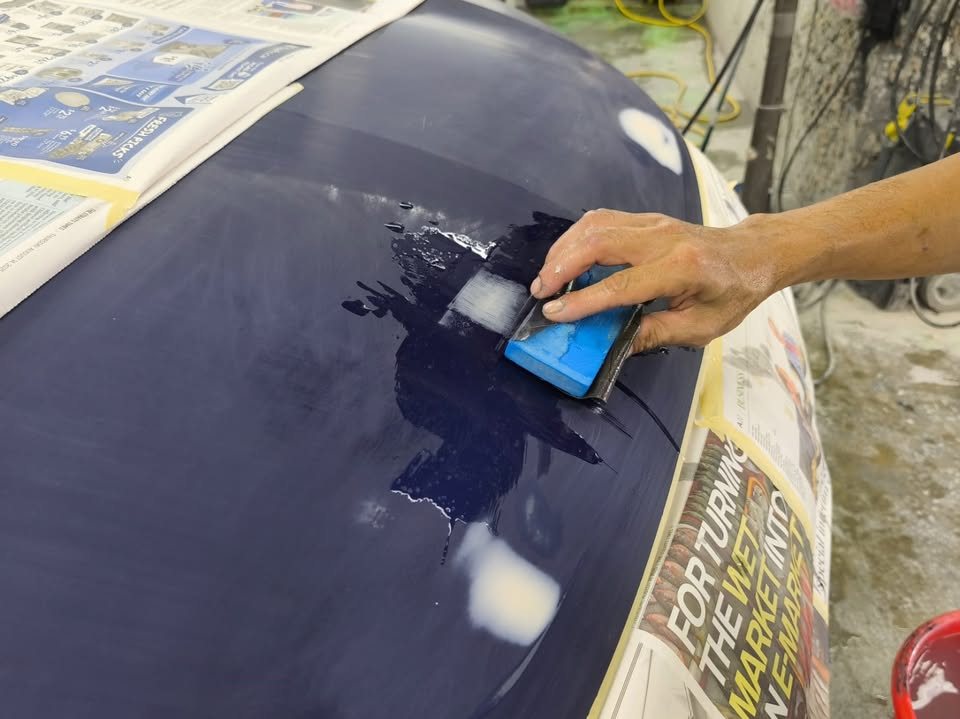 Wet-sanding a patched area on the Outlander's tailgate.