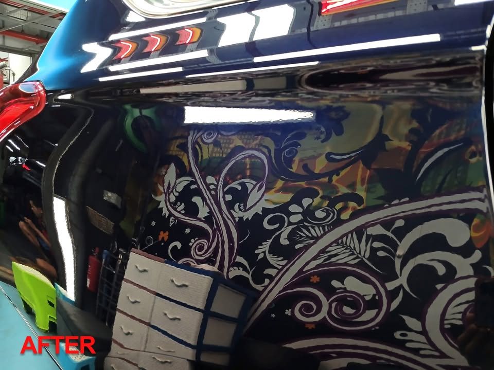 Rear quarter of the dark blue Outlander reflecting the workshop's mural after the respray.
