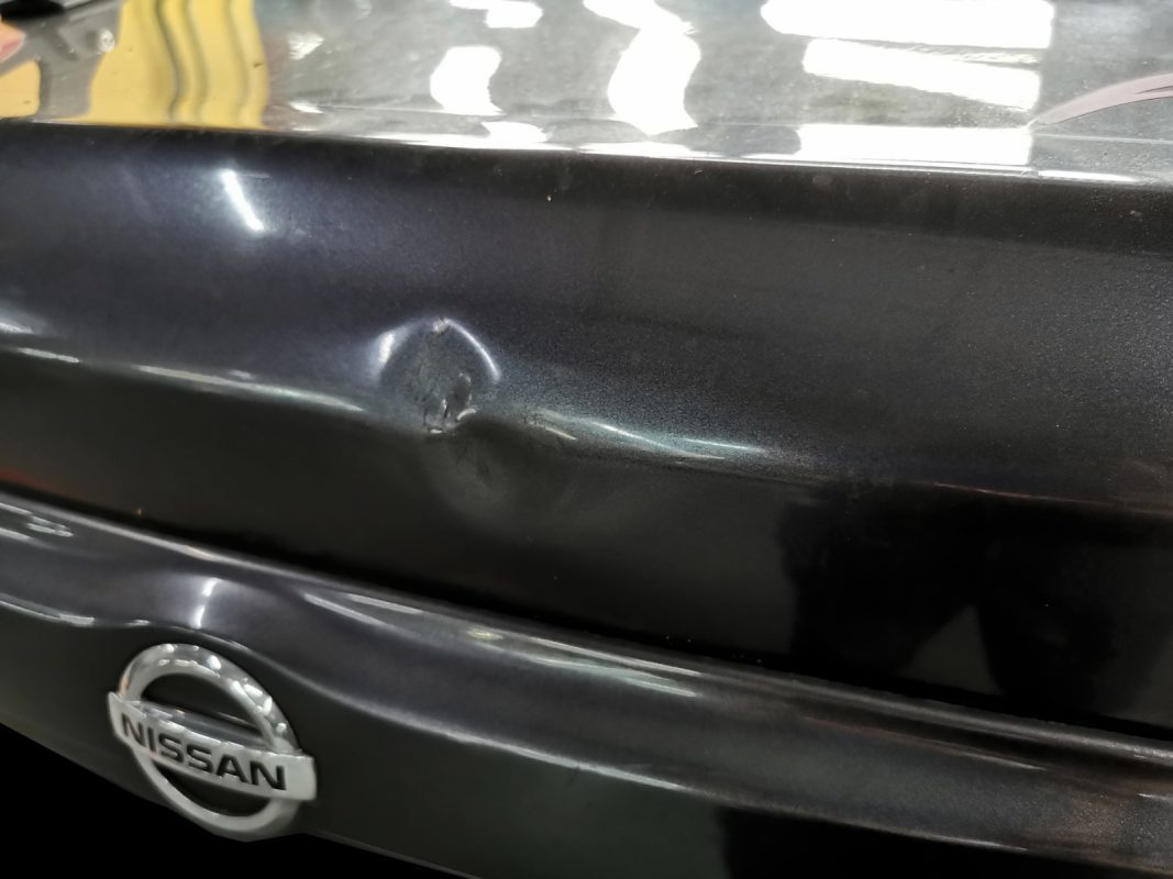 The Nissan Almera from the rear, paintwork showing its age before the respray.