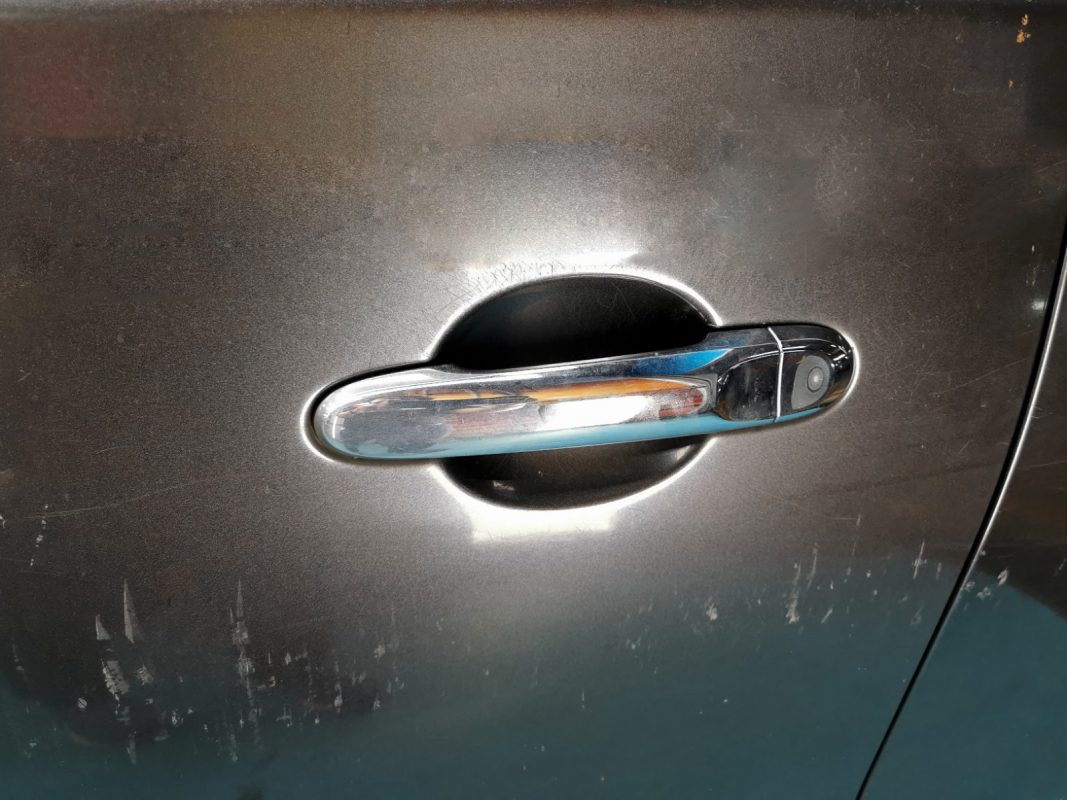 Non-painted surfaces being masked on the Nissan Almera to prevent overspray.